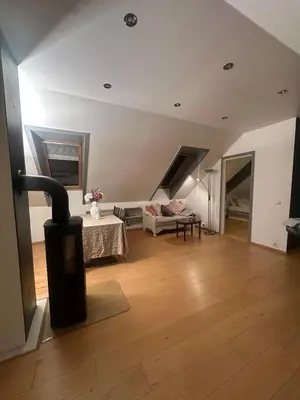 a living room with a couch and a table at Bright loft apartment in a Jugend-style building close to Brosund in Ålesund