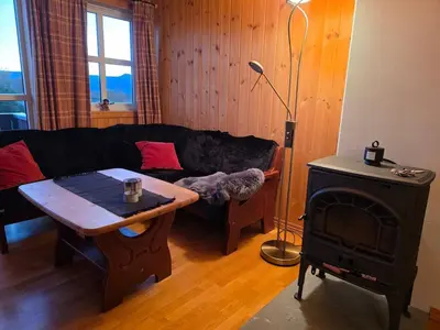 a living room with a couch and a wood stove at Fjellstolen apartment nr 12 in Beitostøl