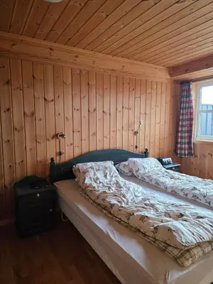 a bedroom with a bed in a wooden wall at Fjellstolen apartment nr 12 in Beitostøl