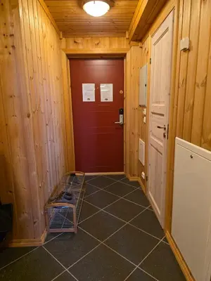 a hallway with a door and a tiled floor at Fjellstolen apartment nr 12 in Beitostøl