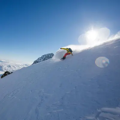 a person riding a snowboard down a snow covered slope at Timber Cabin With Mountain View in Beitostøl