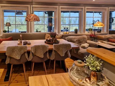 a living room with a large table and chairs at Cozy Family Cabin At Hamlagrø in Vossevangen
