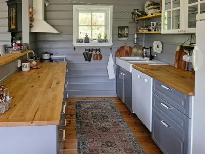 a kitchen with blue cabinets and a wooden floor at Cozy Family Cabin At Hamlagrø in Vossevangen