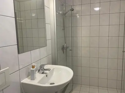 a white bathroom with a sink and a shower at Hjemmekoselig Toppleilighet I Sentrum in Beitostøl