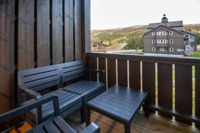 a bench sitting on a balcony with a view at Høyfjellsgrend 961, 36b in Trysil