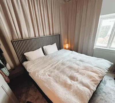 a bedroom with a large white bed with a window at Toppleilighet i sentrum av øystese in Kvam