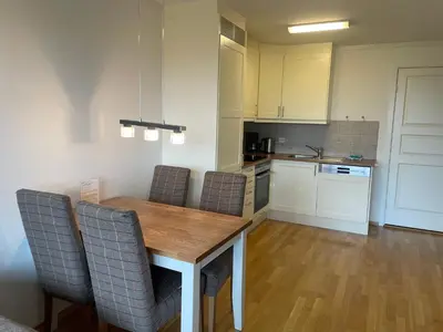 a kitchen with a wooden table and chairs at Leilighet For 4 I Sentrum in Beitostøl
