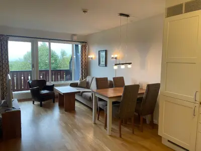 a living room with a table and a couch at Leilighet For 4 I Sentrum in Beitostøl