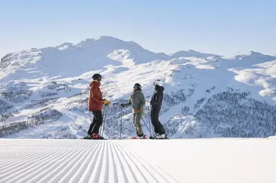 three people standing on top of a snow covered mountain at Ski in-Ski out with Sauna and Modern Mountain Comfort in Hemsedal