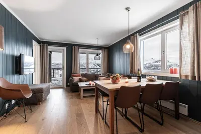 a living room with a table and a couch at Ski in-Ski out and True Mountain Charm in Hemsedal