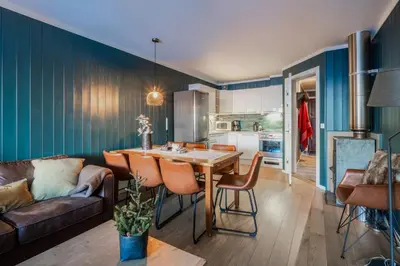 a kitchen and living room with a table and a couch at Ski in-Ski out with Style and Scenic Views in Hemsedal