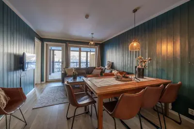 a living room with a wooden table and a couch at Ski in-Ski out with Style and Scenic Views in Hemsedal