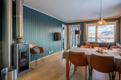 a living room with a table and a fireplace at Ski in-Ski out and Perfect for Families in Hemsedal