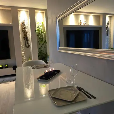 a white table with glasses and a mirror on the wall at Apartment, everything close in Hamar