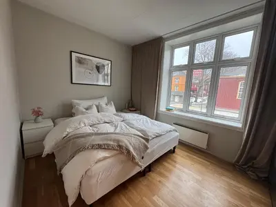 a bedroom with a bed and a large window at Nice apartment super central at Solsiden in Trondheim