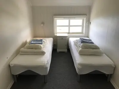 two beds in a small room with a window at Strand farm, sea view and boat rental in Averoy