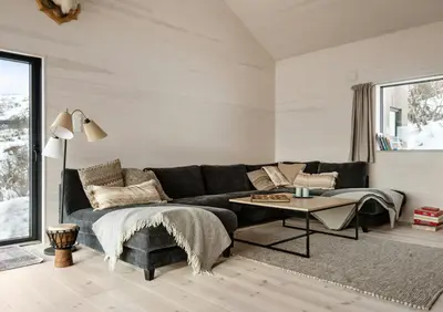 a living room with a black couch and a table at New Cabin With Panoramic Views At Hardangervidda in Eidfjord