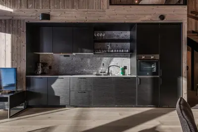 a kitchen with black cabinets and a sink at Kikut Alpin Lodge 1302 in Geilo