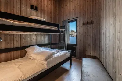 a bedroom with two bunk beds and a window at Kikut Alpin Lodge 1302 in Geilo