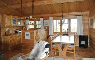 a room with a table and chairs in a cabin at Cozy Home In Rendalen With Sauna in Akrestrommen