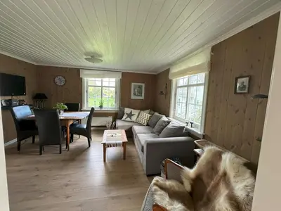 a living room with a couch and a table at Koselig vestlandshus ved fjorden in Holmedal