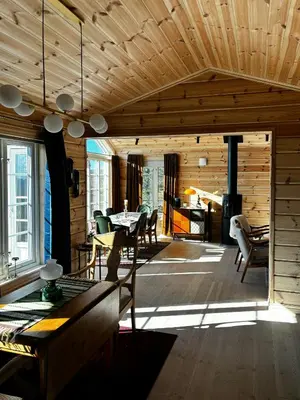 a living room with a table and a fireplace at Mountain Cabin With Panoramic Views In Valdres in Etnedal