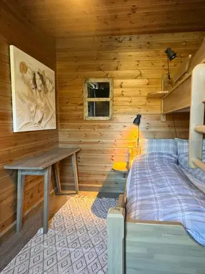 a bedroom with wooden walls and a bed and a desk at Apartment With Panoramic Views In Beitostølen in Beitostøl