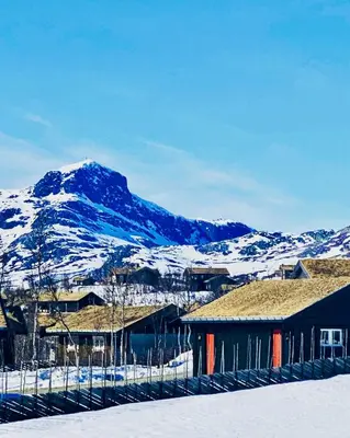 a snow covered mountain in front of a building at Apartment With Panoramic Views In Beitostølen in Beitostøl