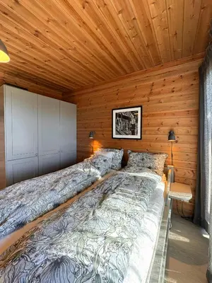 a large bed in a room with wooden walls at Apartment With Panoramic Views In Beitostølen in Beitostøl