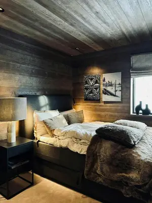 a bedroom with a bed and a wooden wall at Modern Mountain Cabin With Views In Hovden in Hovden