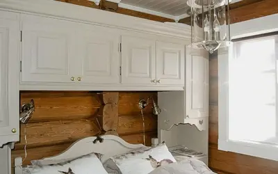 a bedroom with white cabinets and a bed at Log Cabin By Mostertoppen Ski Stadium in Øyer