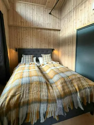 a bed with a blanket and pillows in a bedroom at Modern Apartment In The Heart Of Hovden in Hovden