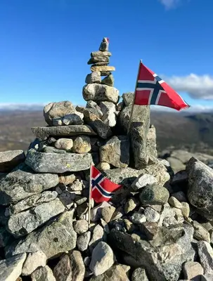 a stack of rocks with a flag on top at Modern Apartment In The Heart Of Hovden in Hovden