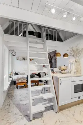 a loft bed in a kitchen with a staircase at Lysthuset den lille villa - authentic wodden house in Bergen