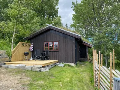 a small cabin with a deck and a grill at Rauland Hytteutleige in Rauland