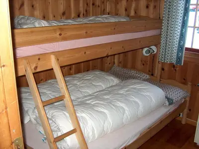 two bunk beds in a wooden room with a ladder at Rauland Hytteutleige in Rauland