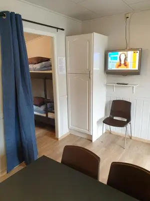 a room with a table and a tv and a bedroom at Tvinde Camping in Skulestadmo
