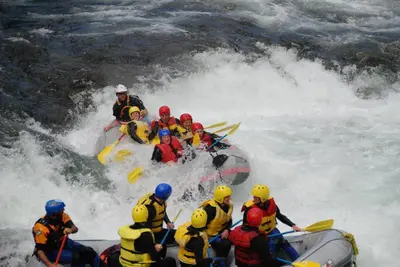 a group of people in a raft on a river at Tvinde Camping in Skulestadmo