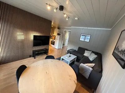 a living room with a table and a couch at Hafjell Ski-in Ski-Out in Øyer