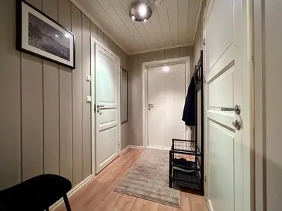 a hallway with a white door and a rug at Hafjell Ski-in Ski-Out in Øyer