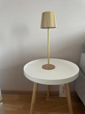 a lamp on a white table next to a couch at Apartament Near Haugesund in Skred