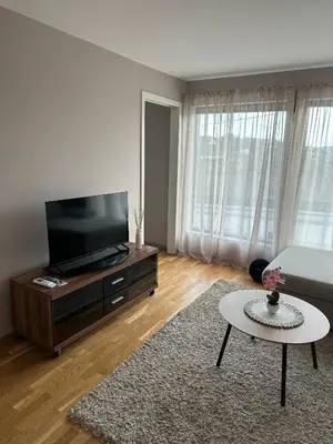 a living room with a flat screen tv and a coffee table at Apartament Near Haugesund in Skred