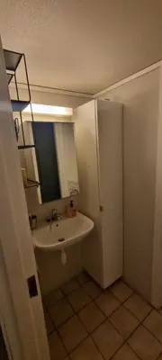 a bathroom with a sink and a toilet and a mirror at Big and cozy room in the middle of the city in Trondheim