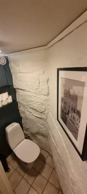 a bathroom with a toilet and a picture on the wall at Big and cozy room in the middle of the city in Trondheim
