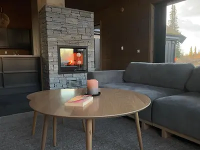 a living room with a couch and a table at Moderne storhytte med 5 soverom og 3 bad in Beitostøl