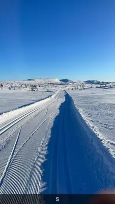 a road in the middle of a snow covered field at Moderne storhytte med 5 soverom og 3 bad in Beitostøl