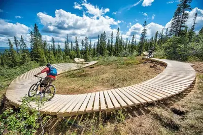 a man riding a bike on a wooden boardwalk at Trysilfjell 752E by Vacation Trysil in Trysil