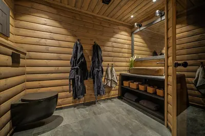 a bathroom with wooden walls and a black toilet at The Nordic Retreat - Stryn in Stryn