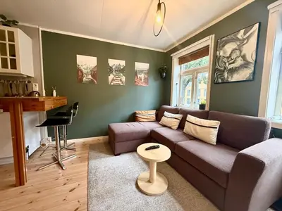 a living room with a couch and a table at Rustic Retreat Apartment, Central & free parking ! in Trondheim