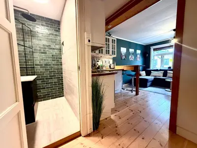 a kitchen and living room with blue walls at Rustic Retreat Apartment, Central & free parking ! in Trondheim